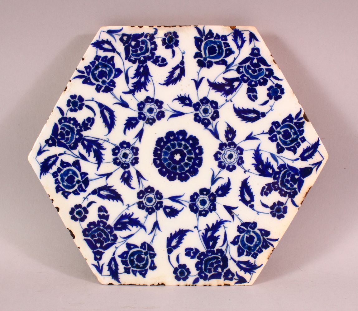 A FINE TURKISH BLUE AND WHITE HEXAGONAL POTTERY TILE, painted with stylised flowers, 24cm diameter.