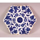 A FINE TURKISH BLUE AND WHITE HEXAGONAL POTTERY TILE, painted with stylised flowers, 24cm diameter.