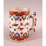 A TURKISH POTTERY IZNIK CUP / MUG - with red green and blue decoration, 13cm high