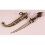 A LARGER NORTH AFRICAN METAL DRESS DAGGER, with a wooden handle, steel blade and decorated sheath,