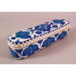 A TURKISH OTTOMAN KUTAHYA POTTERY PEN BOX & COVER, in blue and white floral decoration, 23cm