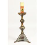 AN EARLY ORIENTAL CHAMPLEVE ENAMEL CANDLESTICK, 12ins high.