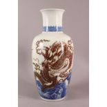 A LARGE CHINESE UNDERGLAZE BLUE & COPPER RED PORCELAIN VASE, decorated with dragons amongst waves,