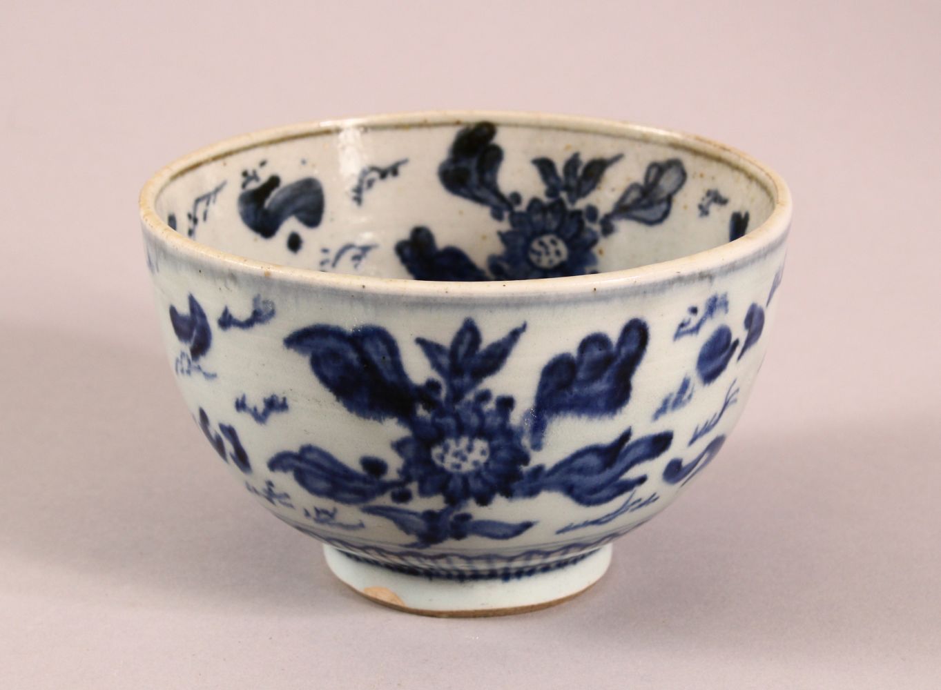 A SMALL CHINESE BLUE AND WHITE BOWL, painted with fish and flora, 12cm diiameter, 7.5cm high.