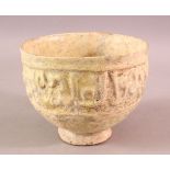 A 12TH CENTURY KUFIC SCRIPT GLAZED POTTERY BOWL, the exterior with moulded script, 15cm diameter,