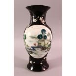 A 19TH CENTURY CHINESE FAMILLE NOIR PORCELAIN VASE, the black ground decorated with panels of