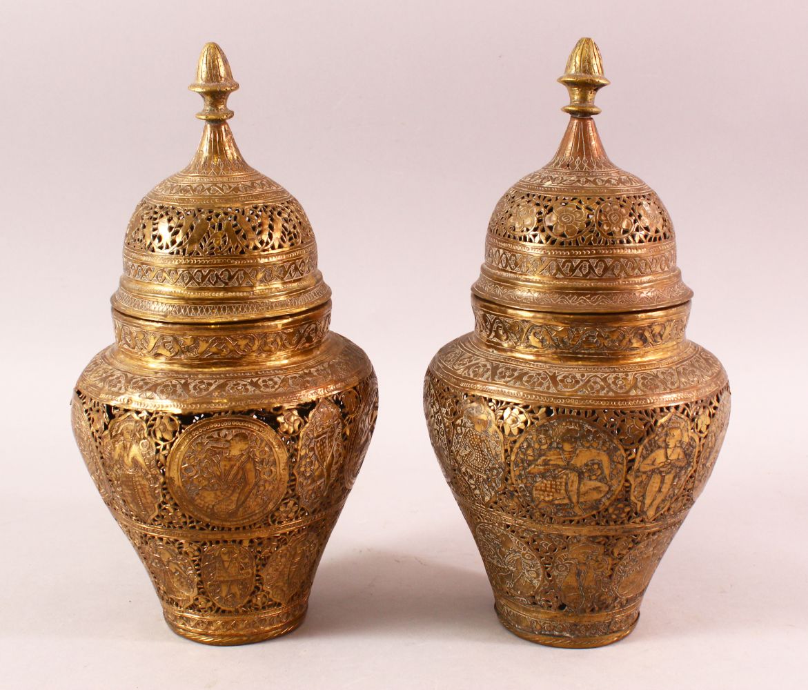 A PAIR OF QAJAR OPENWORK BRASS VASES & COVERS, with roundel figural decoration, 28cm