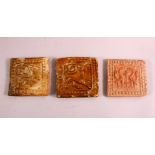 THREE 16TH CENTURY POTTERY TILE SECTIONS, each with moulded decoration of animals, 11cm approx. (3)