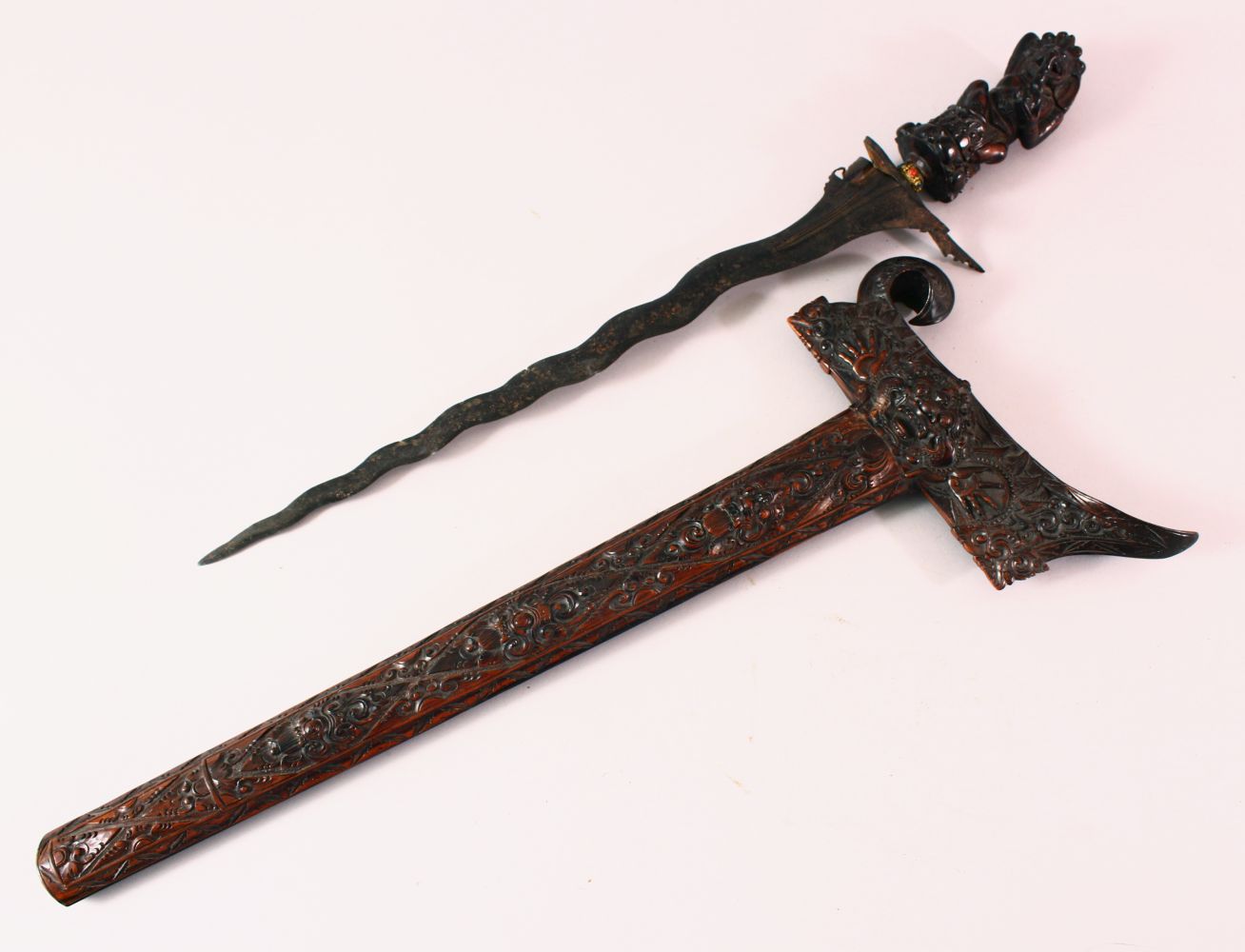 A GOOD INDONESIAN CARVED WOODEN SWORD / DAGGER, the well carved dagger with an elephant carved deity