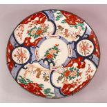 A LARGE JAPANESE MEIJI PERIOD PORCELAIN IMARI CHARGER, depicting shi shi dogs with floral