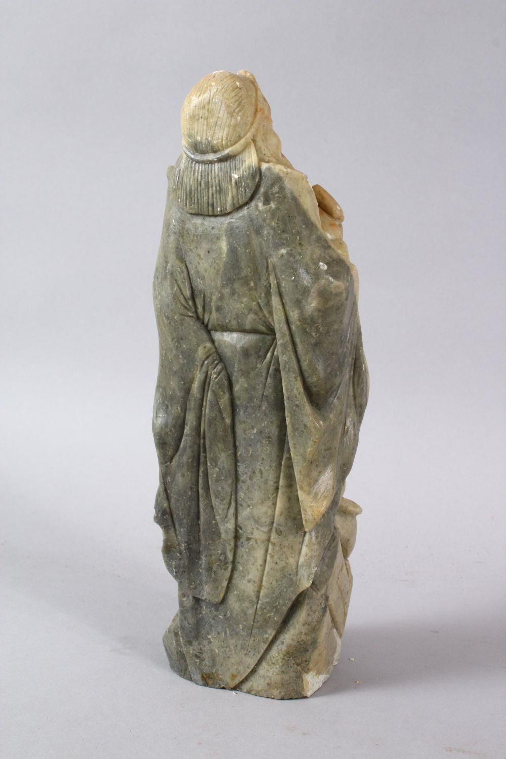 A LARGE CHINESE SOAPSTONE CARVING OF AN IMMORTAL, stood upon a rocky outcrop with a double groud, - Image 3 of 6