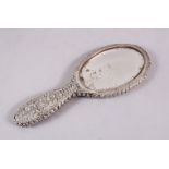 A 19TH CENTURY INDIAN SILVER HAND MIRROR, with embossed decoration of flora, 24cm.