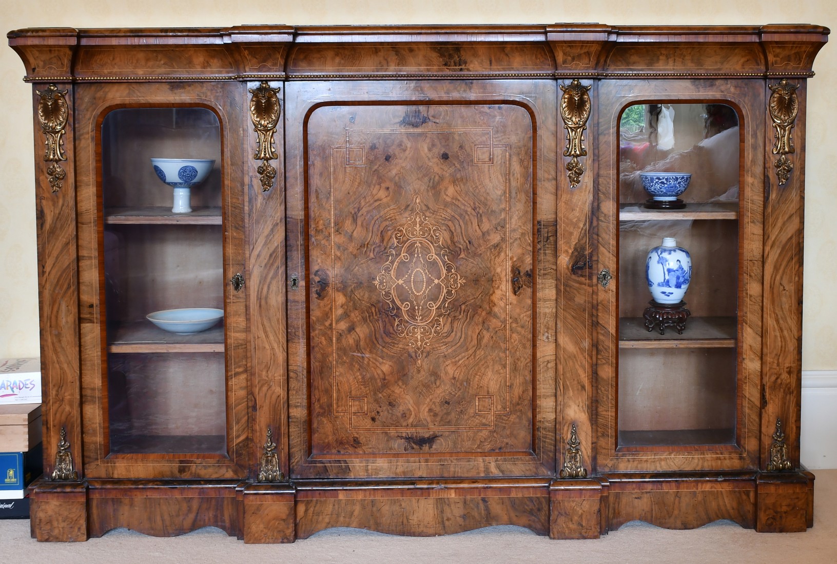 A GOOD VICTORIAN FIGURED WALNUT CREDENZA, the front with central panel drawer, flanked by glass