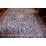 A VERY GOOD LARGE PERSIAN FLORAL CARPET, mainly in red and blue. 11ft 6ins x 8ft 6ins.