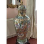 A LARGE CANTON DESIGN PORCELAIN VASE AND COVER, on a wooden stand. 3ft 4ins high.