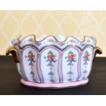 A FRENCH PORCELAIN OVAL SHAPED JARDINIERE painted with panels of flowers, with gilt handles. 11ins
