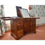 A GENTLEMAN'S MAHOGANY DRESSING TABLE with folding flaps, mirror, powder and other compartments with
