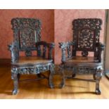 A GOOD PAIR OF CHINESE CARVED AND PIERCED ARMCHAIRS with solid seats, dragon arms and foliage.