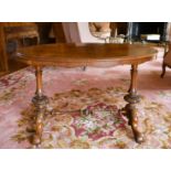 A VICTORIAN OVAL WALNUT STRETCHER TABLE with turned supports, curving legs with white porcelain