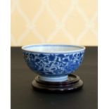 A CHINESE BLUE AND WHITE CIRCULAR BOWL. 4.5ins diameter, on a wooden stand.