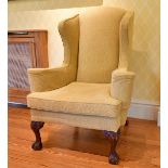 A GEORGE III STYLE MAHOGANY WING BACK ARMCHAIR, on carved cabriole legs ending in claw and ball