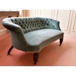 A VICTORIAN SHAPED BUTTON BACK SETTEE on turned legs and castors. 4ft 9ins long.