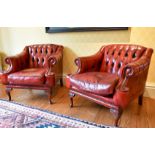 A MATCHING PAIR OF BUTTONED BACK ARMCHAIRS.