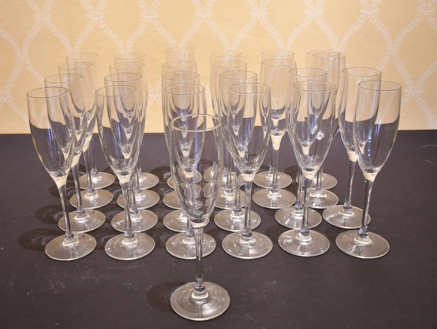 A SET OF TWENTY-FIVE PLAIN GLASS CHAMPAGNE FLUTES.