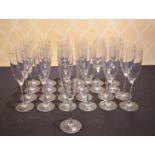 A SET OF TWENTY-FIVE PLAIN GLASS CHAMPAGNE FLUTES.