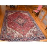 A LARGE GOOD PERSIAN CARPET with large central medallion, mainly in reds and blues. 12ft x 9ft