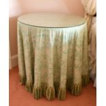 A GLASS TOP CIRCULAR TABLE with fabric cover. 2ft 4ins diameter.