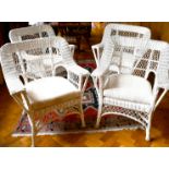 A SET OF FOUR WHITE PAINTED CANE ARMCHAIRS with loose cushions.