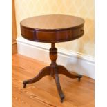 A REPRODUCTION MAHOGANY SMALL CIRCULAR TOP DRUM TABLE with two drawers, on a centre pillar and