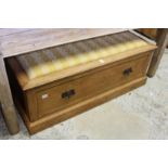 An oak ottoman with a storage drawer