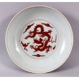 A CHINESE MING STYLE COPPER RED PORCELAIN DRAGON DISH, the interior with moulded relief copper red