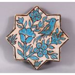 AN IRANIAN TURQUOISE GLAZE STAR FORMED POTTERY TILE, decorated with bird upon branches, 17cm