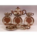 A CHINESE YIXING POTTERY WHITE METAL OVERLAID TEAPOT with four matching cups and saucers, teapot: