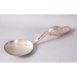 A LARGER BURMESE WHITE METAL MOULDED SERVING SPOON, the spoon with an embossed decorated floral