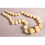 AN IVORY BEAD NECKLACE, comprising 26 facet beads, largest 33mm wide, 46cm long. Weight 108g.