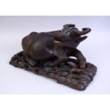 A GOOD 19TH CENTURY CHINESE CARVED HARDWOOD AND INLAID SILVER WATER BUFFALO, the buffalo recumbent
