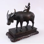 AN INDIAN JAIPUR SCHOOL BRONZE MODEL OF A COW, with a boy seated upon its back