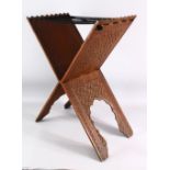 AN ISLAMIC CARVED WOODEN QURAN STAND - carved profusely with scrolling foliate decoration, with