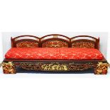 AN IMPRESSIVE CHINESE CARVED GILDED AND RED LACQUERED SETTEE, the triple humped back with gilded