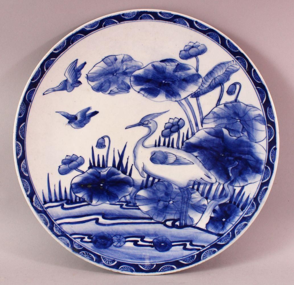 A JAPANESE BLUE & WHITE PORCELAIN PLATE, poss arita, decorated with a bird amongst lotus, the