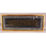 A LARGE ISLAMIC CALLIGRAPHIC SCRIPT PICTURE - the script in gilt , housing in gilt frame, 80cm x