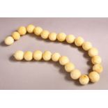 AN IVORY BEAD NECKLACE, comprising 24 spherical beads, largest bead 15mm wide, overall 42cm long.