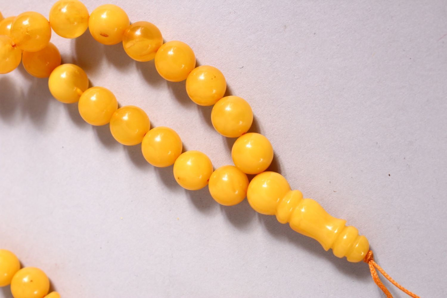 A CHINESE QING DYNASTY CARVED AMBER PRAYER BEADS / ROSARY NECKLACE, comprising 66 beads, 3 spacers - Image 2 of 3