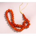 A SET OF 19TH CENTURY CARVED AMBER BEAD NECKLACE - Comprising 34 carved beads, 2 spacers and one