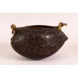 A SMALL ISLAMIC CARVED COCO KASHKOOL, the sides carved with calligraphy, with two brass ring