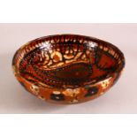 A SMALL PERSIAN BROWN GLAZED TERRACOTTA BOWL, the inner decorated with a stylised bird, 18cm